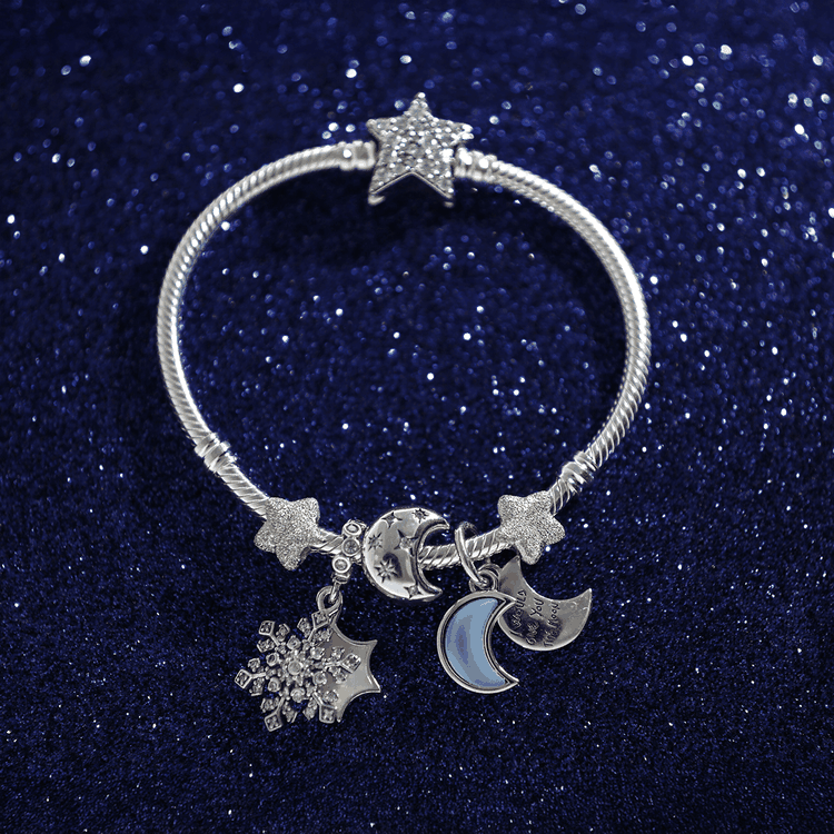 Pandora csillagos karkötő hold függővel és hópehely charmmal Csillagos Pandora karkötő hold alakú függővel, csillogó hópehely charmmal és ezüst csillagokkal.